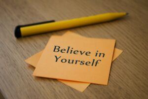 a few post it notes that one says believe in yourself with a pencil next to them